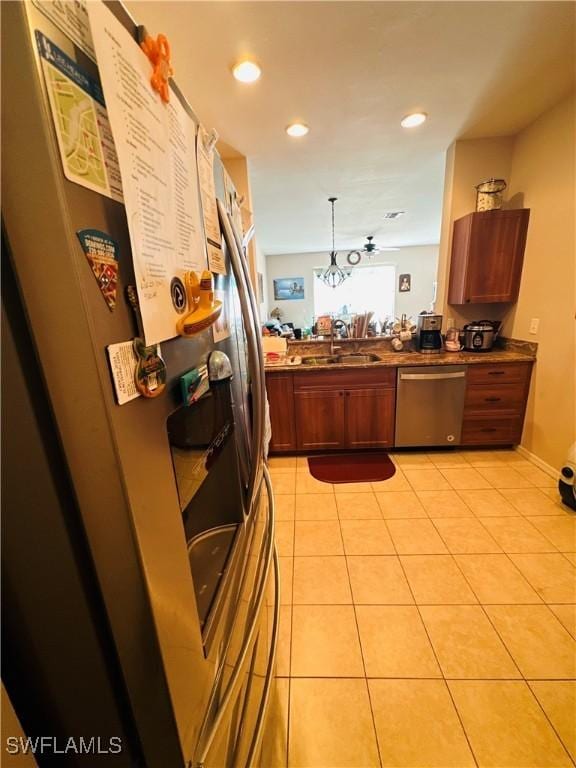 kitchen featuring sink, a notable chandelier, decorative light fixtures, light tile patterned flooring, and appliances with stainless steel finishes