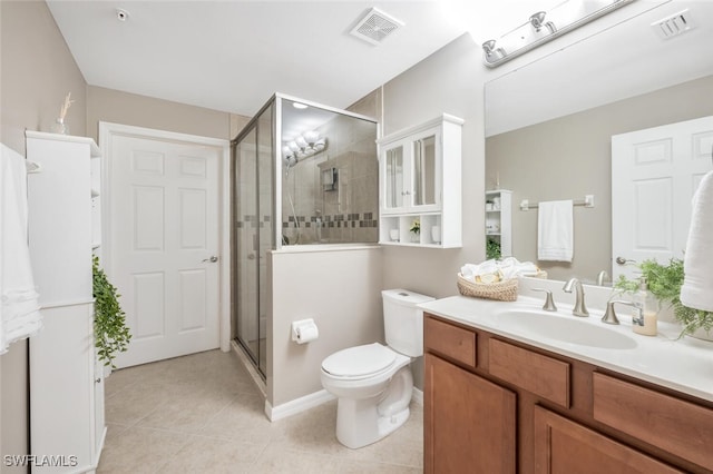 bathroom with tile patterned floors, vanity, toilet, and a shower with door