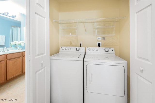 laundry room featuring washing machine and dryer, light tile patterned floors, and sink