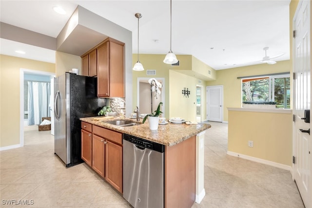 kitchen with sink, ceiling fan, decorative light fixtures, light stone counters, and stainless steel appliances