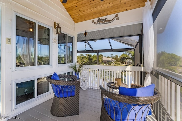 sunroom / solarium featuring vaulted ceiling, plenty of natural light, and wood ceiling