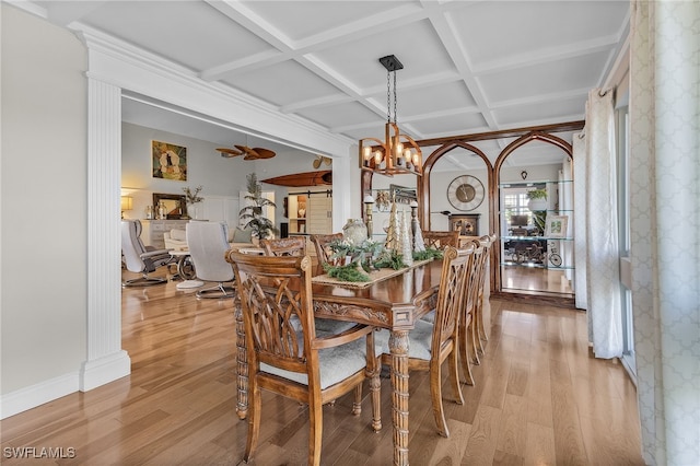 dining area featuring a chandelier, light hardwood / wood-style floors, and coffered ceiling