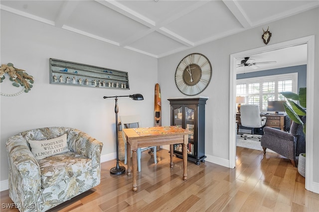 living area featuring beam ceiling, ceiling fan, wood-type flooring, and coffered ceiling