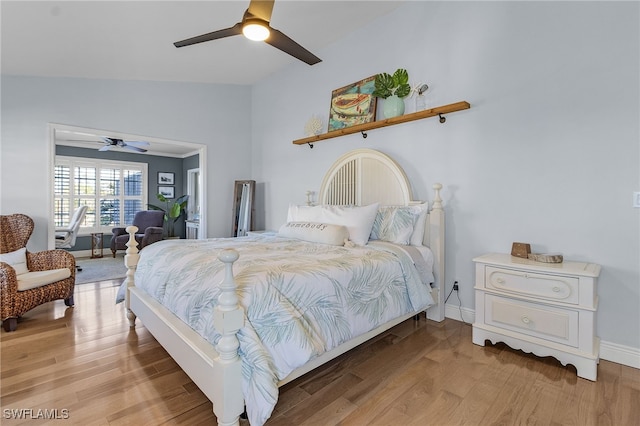 bedroom with ceiling fan, light hardwood / wood-style flooring, and lofted ceiling