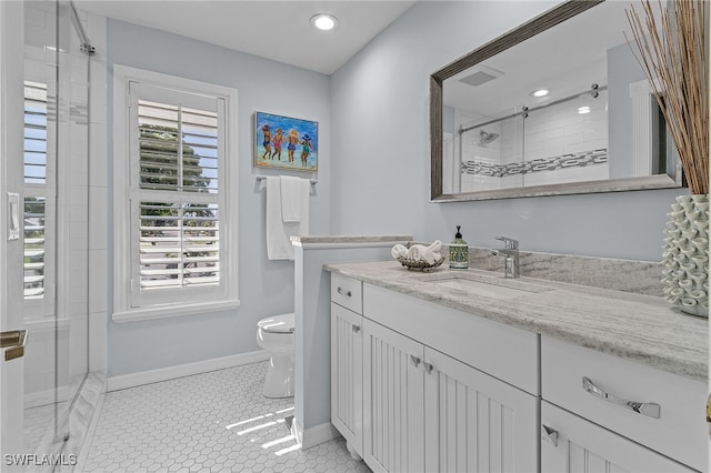 bathroom with tile patterned floors, vanity, a shower with shower door, and toilet