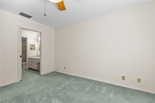 unfurnished bedroom featuring ensuite bathroom, ceiling fan, and light carpet