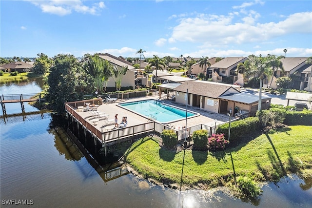 view of swimming pool with a yard and a water view