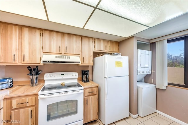 kitchen with light brown cabinets, light tile patterned flooring, white appliances, and stacked washer / dryer