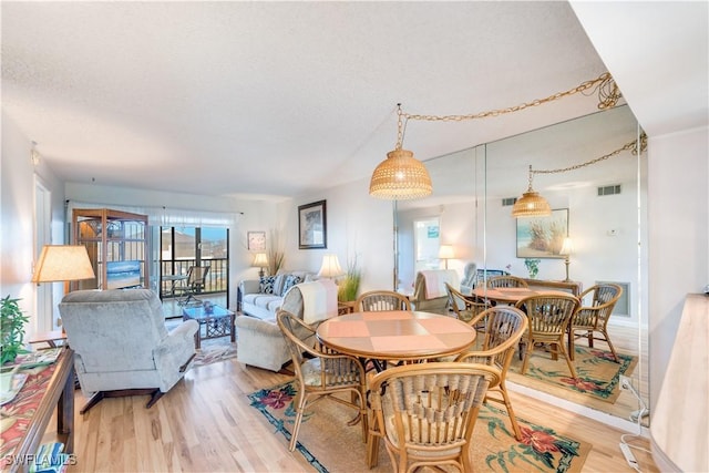 dining area featuring light hardwood / wood-style floors and a textured ceiling