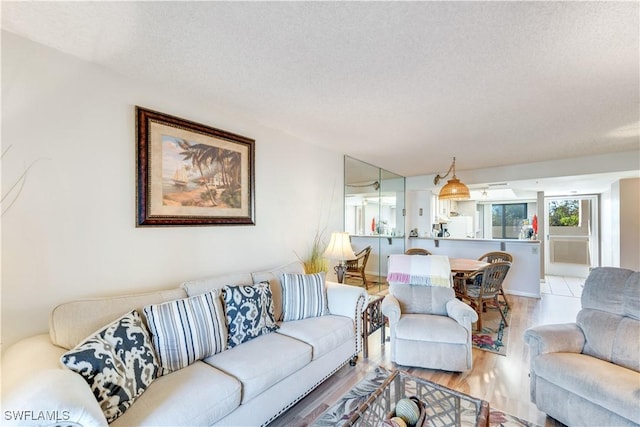 living room with a textured ceiling and light wood-type flooring