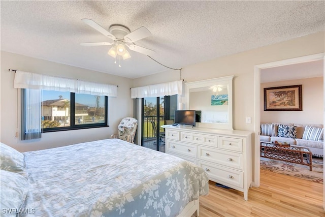 bedroom featuring ceiling fan, a textured ceiling, access to outside, and light hardwood / wood-style flooring