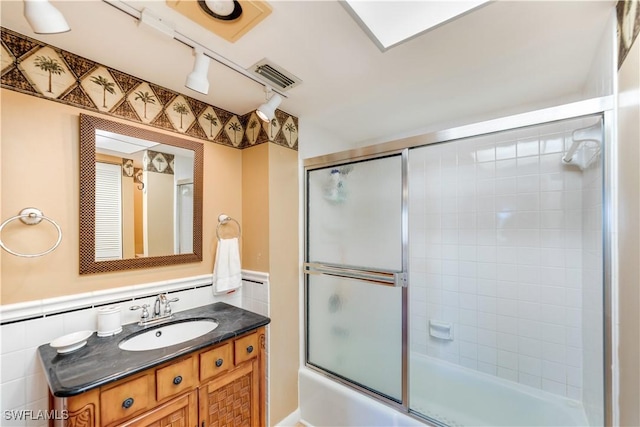 bathroom featuring vanity and bath / shower combo with glass door