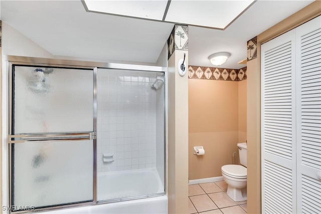 bathroom with tile patterned floors, toilet, and enclosed tub / shower combo