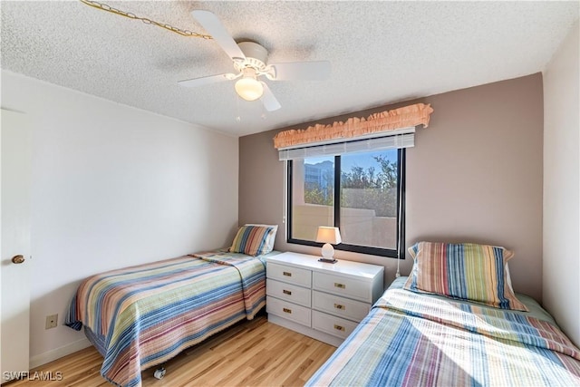 bedroom featuring a textured ceiling, light hardwood / wood-style flooring, and ceiling fan