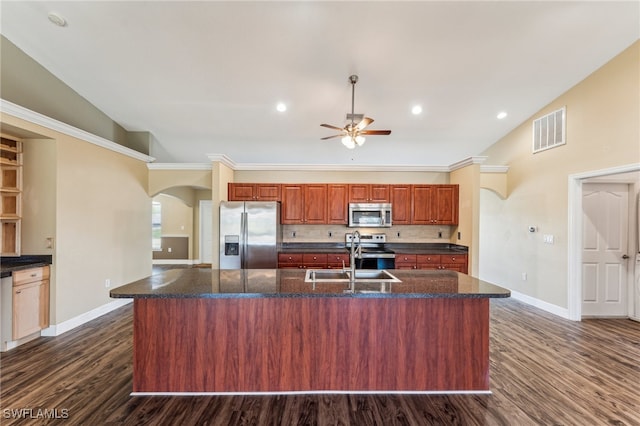 kitchen with appliances with stainless steel finishes, a center island with sink, dark wood-type flooring, and sink