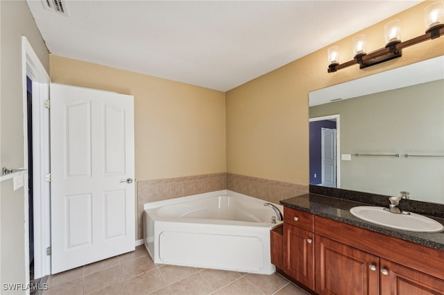 bathroom featuring tile patterned flooring, vanity, and a tub