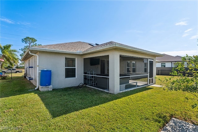 back of property with a lawn and a sunroom