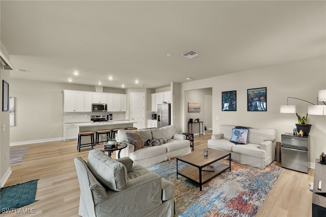 living room featuring light wood-type flooring and sink