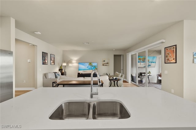 kitchen with stainless steel fridge, light wood-type flooring, and sink