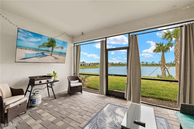 sunroom / solarium featuring a water view