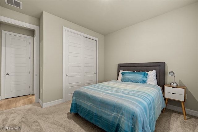 bedroom with a closet and light colored carpet