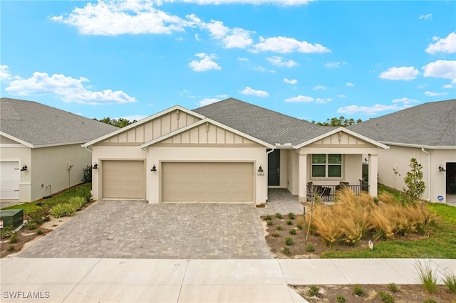 16468 Settlers Way, Punta Gorda, FL 33982 - view of front of house with board and batten siding, decorative driveway, a garage, a porch, and stucco siding