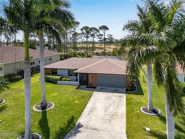 ranch-style house featuring a garage and a front lawn