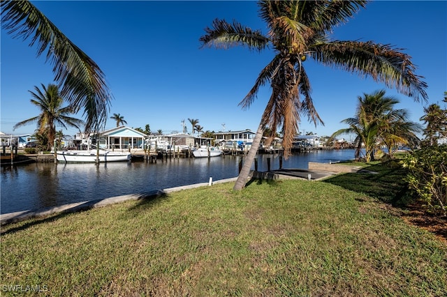 dock area with a water view and a lawn