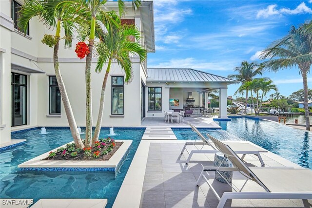 view of pool with a patio area and pool water feature