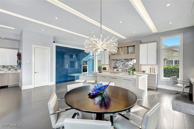 dining area featuring an inviting chandelier, sink, and dark hardwood / wood-style floors