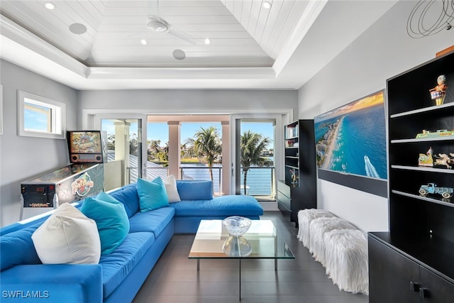 living room featuring wood ceiling, plenty of natural light, and a tray ceiling