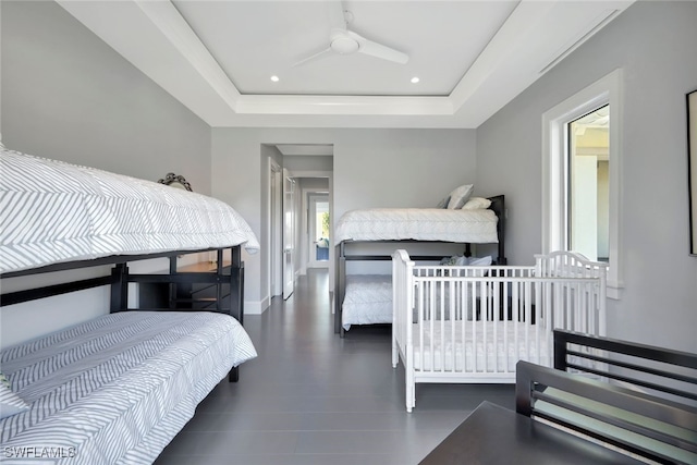 bedroom featuring a raised ceiling and ceiling fan