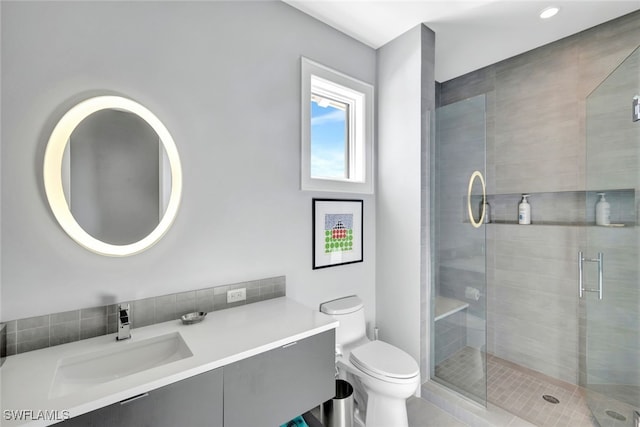 bathroom with vanity, a shower with shower door, and toilet