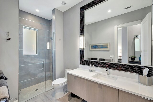 bathroom with vanity, a shower with shower door, and toilet