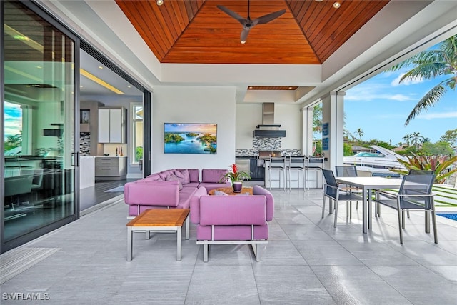 view of patio with outdoor lounge area, ceiling fan, and a bar