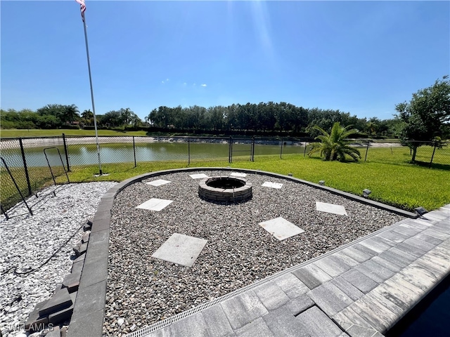 view of yard with a water view and an outdoor fire pit