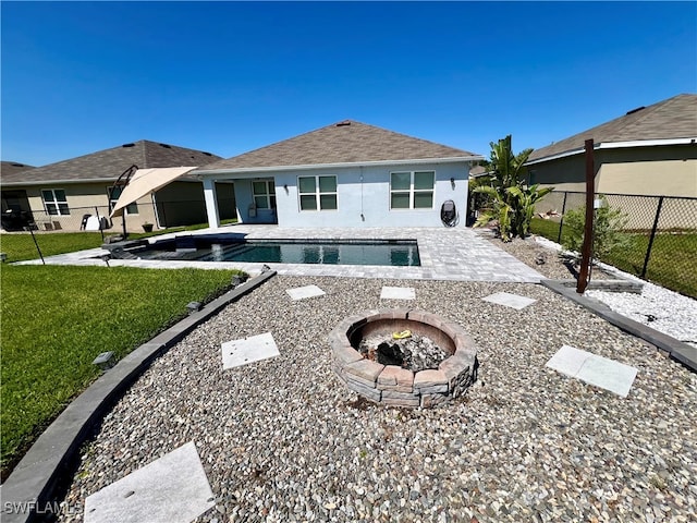 view of pool with a fire pit, a patio area, and a lawn