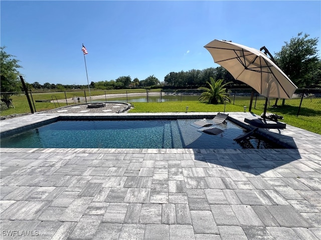 view of pool featuring a lawn, a water view, and a patio