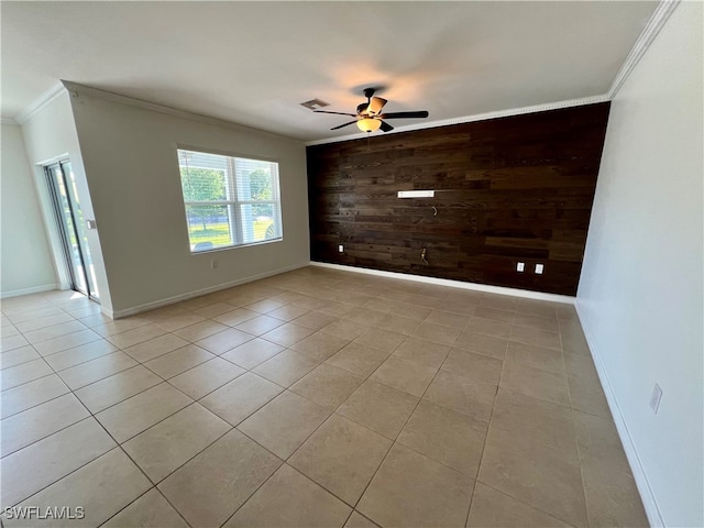 tiled empty room featuring crown molding, ceiling fan, and wooden walls