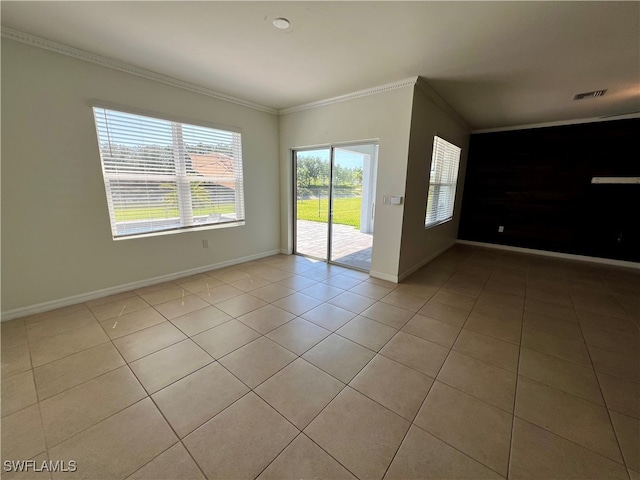 tiled spare room featuring crown molding