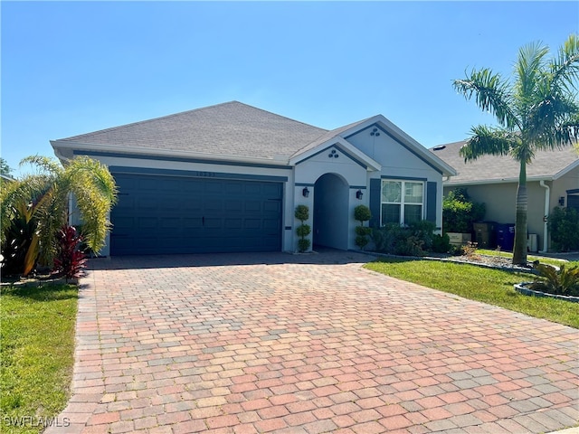 single story home featuring a garage and a front lawn