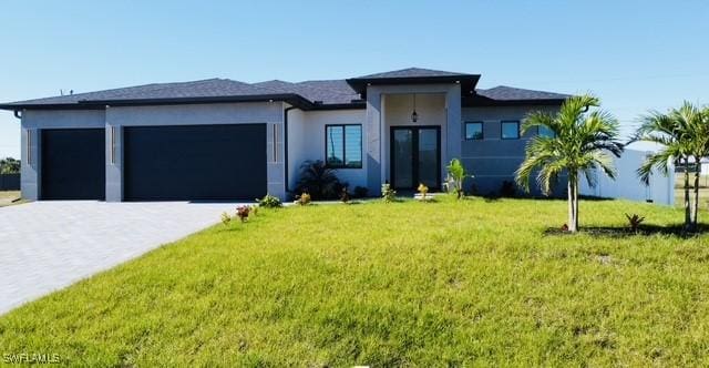 prairie-style home featuring a garage and a front yard