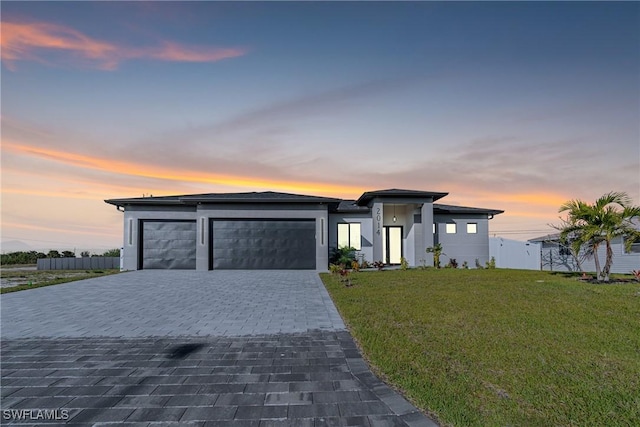 view of front facade featuring a garage and a lawn