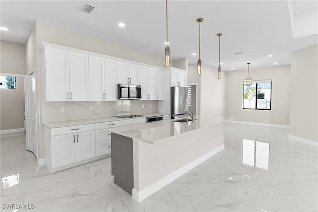 kitchen with refrigerator, hanging light fixtures, white cabinets, a center island with sink, and black electric cooktop