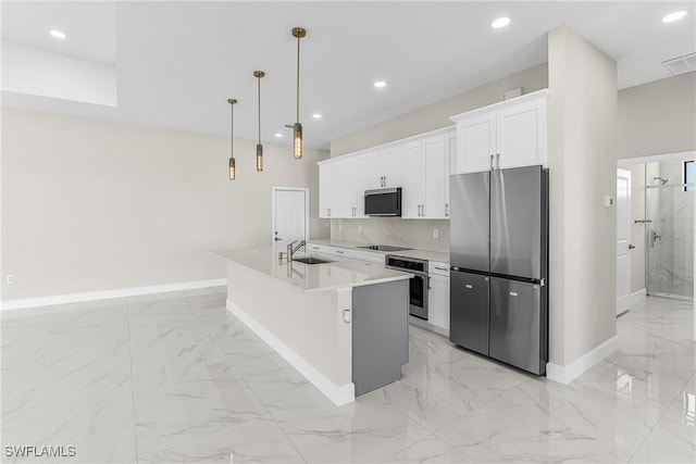 kitchen with white cabinetry, sink, hanging light fixtures, a kitchen island with sink, and stainless steel appliances