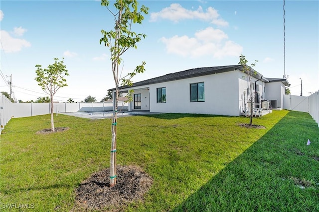 rear view of house featuring a yard, cooling unit, and a patio area