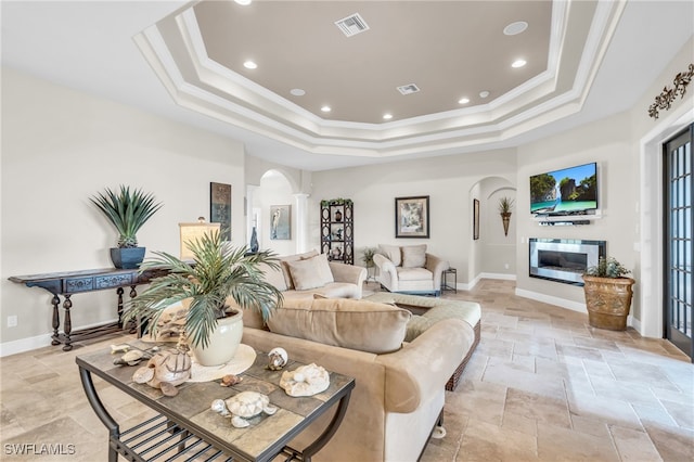 living room with a raised ceiling and crown molding