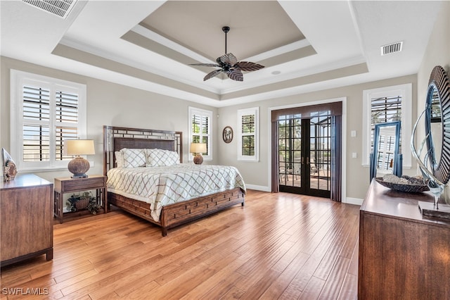 bedroom featuring light hardwood / wood-style floors, multiple windows, and french doors