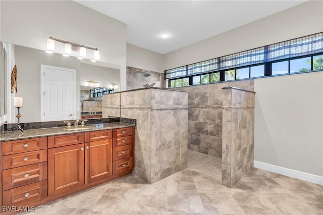 bathroom featuring tile patterned floors, vanity, and a tile shower