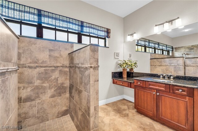 bathroom with vanity and a tile shower